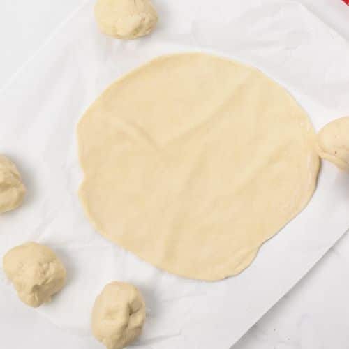 2-Ingredient Tortilla dough rolled on a baking sheet.