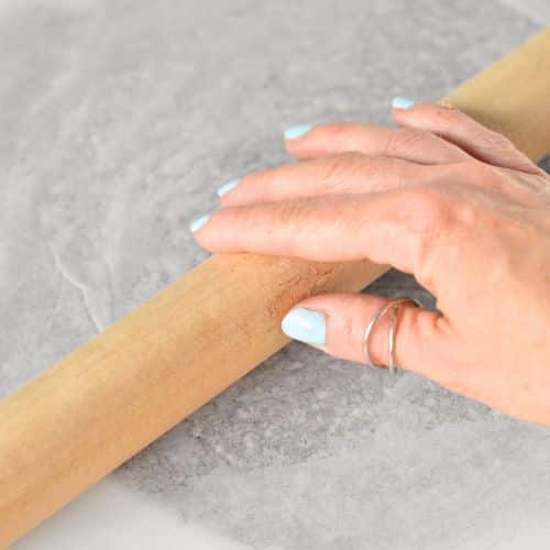 Rolling the Flaxseed Cracker dough between baking sheets.