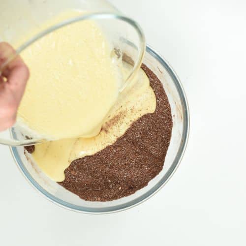 Pouring the liquid mixture on the dry Keto German Chocolate Cake ingredients.