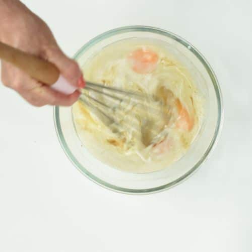 Mixing egg and milk in a bowl.