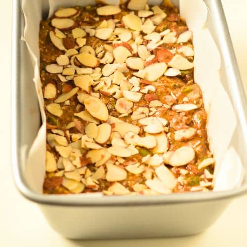 Adding almonds to the Keto Granola Bars in the loaf pan.